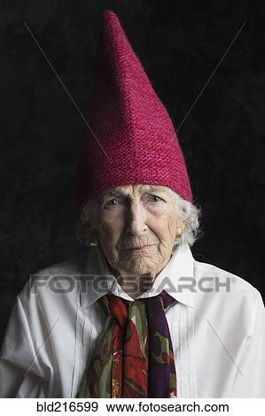 Stock Photo - Close up of older woman wearing dunce cap. Fotosearch