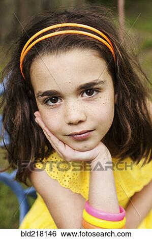Stock Photograph - Close up of pensive girl resting chin in hand. Fotosearch