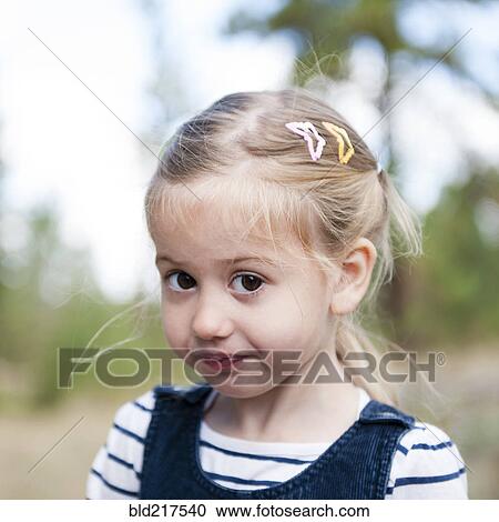 Stock Image - Close up of serious Caucasian girl on hillside. Fotosearch