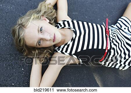 Close up of serious girl laying on pavement View Large Photo Image Stock Image - Close up of serious girl laying on pavement. Fotosearch