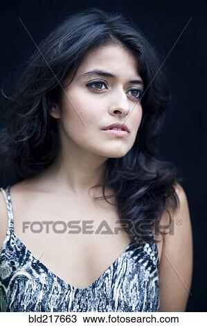 Stock Image - Close up of serious mixed race woman. Fotosearch