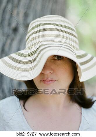 Close up of serious woman wearing sun hat View Large Photo Image Stock Photo - Close up of serious woman wearing sun hat. Fotosearch