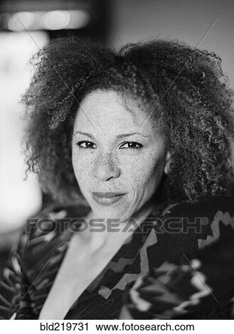 Stock Image - Close up of serious woman with curly hair. Fotosearch