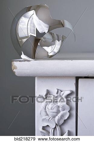 Stock Photo - Close up of shattered metal bulb on table. Fotosearch