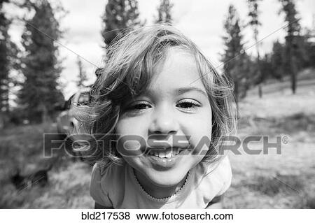 Stock Photo - Close up of smiling Caucasian girl on hillside. Fotosearch