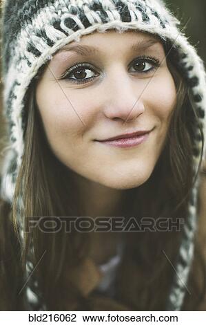 Stock Image - Close up of smiling Caucasian woman wearing knitted hat. Fotosearch