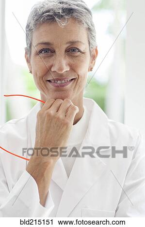 Close up of smiling doctor resting chin in hand View Large Photo Image Stock Image - Close up of smiling doctor resting chin in hand. Fotosearch