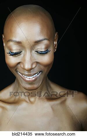 Stock Photography - Close up of smiling face African American woman looking down. Fotosearch