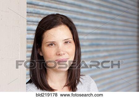 Close up of smiling woman standing by garage door View Large Photo Image Stock Photo - Close up of smiling woman standing by garage door. Fotosearch