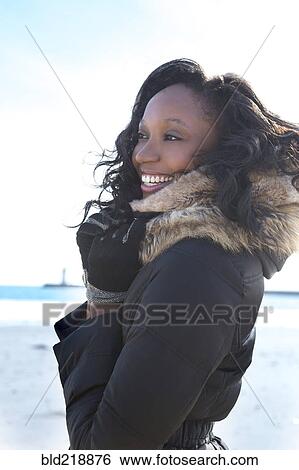 Stock Photograph - Close up of smiling woman wearing coat. Fotosearch