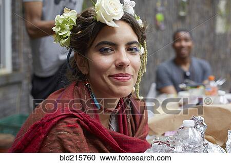 Stock Image - Close up of smiling woman wearing flowers and shawl. Fotosearch