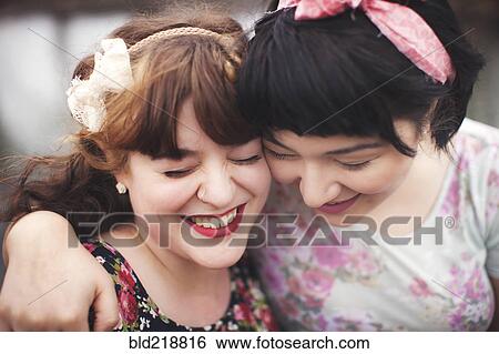 Stock Photograph - Close up of smiling women hugging. Fotosearch
