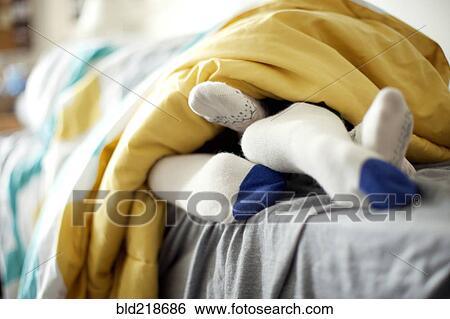 Stock Photograph - Close up of socks of couple in bed. Fotosearch