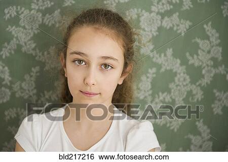 Close up of somber Caucasian girl near wallpaper View Large Photo Image Stock Photograph - Close up of somber Caucasian girl near wallpaper. Fotosearch