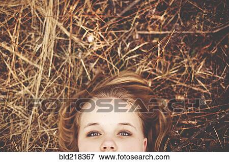 Stock Photo - Close up of teenage girl laying in tall grass. Fotosearch