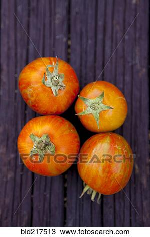 Stock Image - Close up of variety of fresh tomatoes on board. Fotosearch