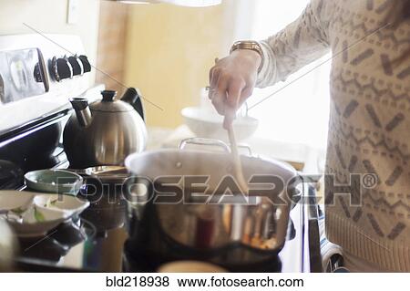 Close up of woman cooking in kitchen View Large Photo Image Stock Photo - Close up of woman cooking in kitchen. Fotosearch