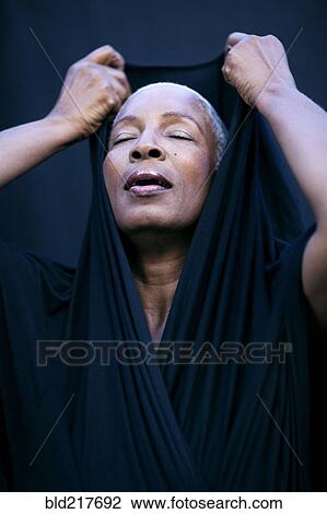 Close up of woman covering her head with shawl View Large Photo Image Stock Image - Close up of woman covering her head with shawl. Fotosearch