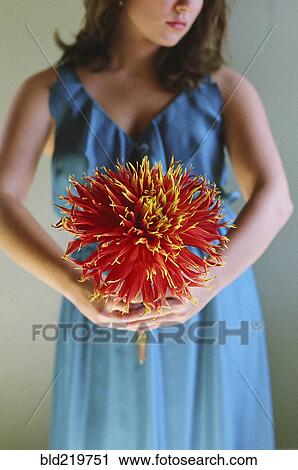 Stock Image - Close up of woman holding flower. Fotosearch