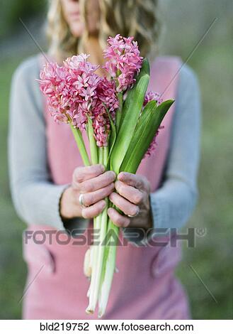 Close up of woman holding flower View Large Photo Image Stock Image - Close up of woman holding flower. Fotosearch