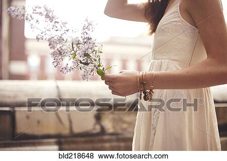 Stock Photo - Close up of woman holding flowers. Fotosearch