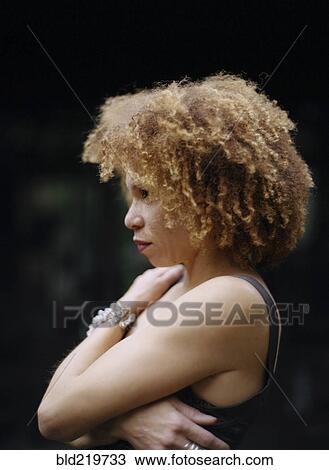 Stock Image - Close up of woman hugging her chest. Fotosearch