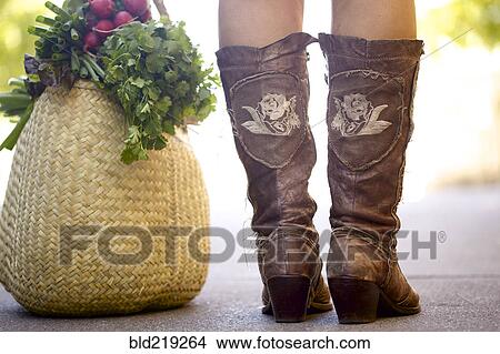 Close up of woman in boots with bag of produce View Large Photo Image Picture - Close up of woman in boots with bag of produce. Fotosearch