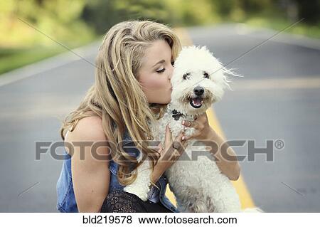 Close up of woman kissing dog on empty road View Large Photo Image Stock Photo - Close up of woman kissing dog on empty road. Fotosearch
