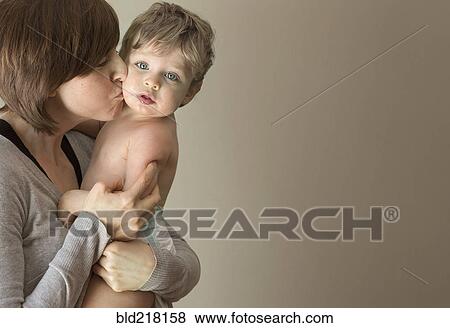 Close up of woman kissing son on cheek View Large Photo Image Stock Photo - Close up of woman kissing son on cheek. Fotosearch