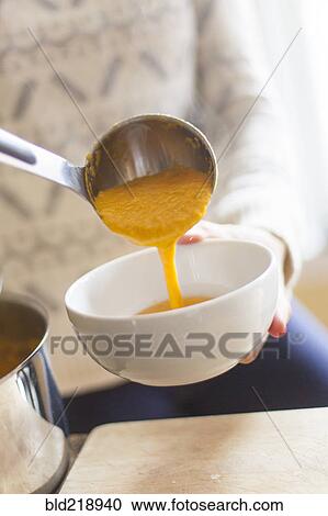 Close up of woman ladling bowl of soup View Large Photo Image Stock Image - Close up of woman ladling bowl of soup. Fotosearch