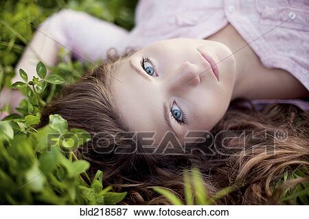 Close up of woman laying in grass View Large Photo Image Stock Photo - Close up of woman laying in grass. Fotosearch