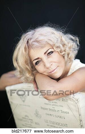 Stock Photo - Close up of woman leaning on chair back. Fotosearch
