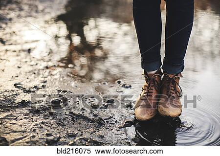Stock Photography - Close up of woman standing in puddle. Fotosearch