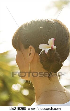 Close up of woman wearing flower in her hair View Large Photo Image Stock Photo - Close up of woman wearing flower in her hair. Fotosearch