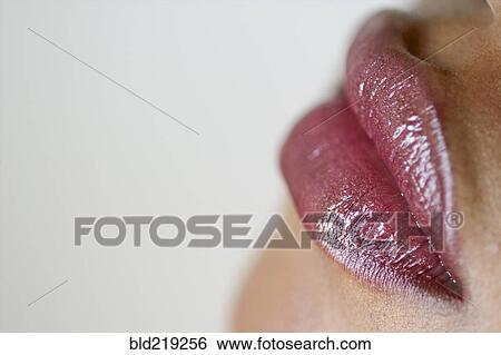 Stock Photograph - Close up of woman wearing lip gloss. Fotosearch
