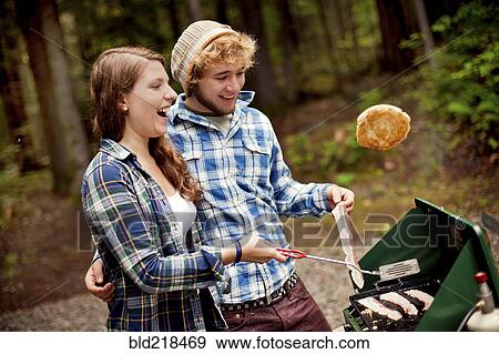 Couple cooking at camp stove in forest View Large Photo Image Stock Photo - Couple cooking at camp stove in forest. Fotosearch