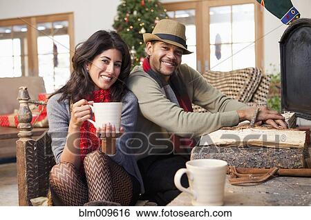 Stock Photograph - Couple drinking coffee in living room. Fotosearch