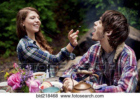Couple feeding each other in forest View Large Photo Image Stock Photo - Couple feeding each other in forest. Fotosearch