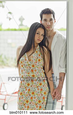 Stock Image - Couple holding hands in doorway. Fotosearch