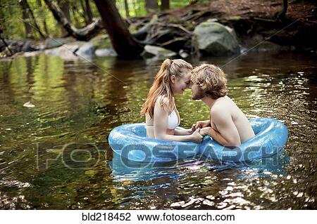 Stock Image - Couple holding hands in forest river. Fotosearch