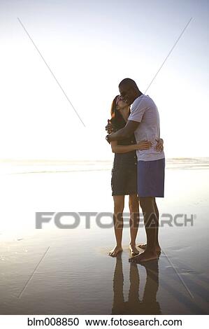 Couple hugging and kissing on beach View Large Photo Image Stock Image - Couple hugging and kissing on beach. Fotosearch