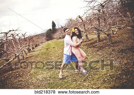 Couple hugging and taking photographs in vineyard View Large Photo Image Stock Photo - Couple hugging and taking photographs in vineyard. Fotosearch