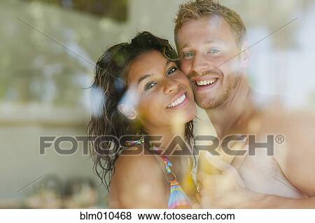 Stock Photo - Couple hugging behind window. Fotosearch
