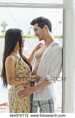 Stock Image - Couple hugging in doorway. Fotosearch
