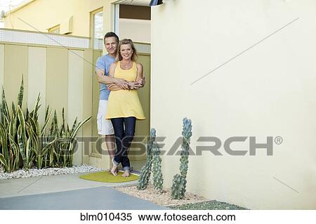 Stock Photography - Couple hugging in doorway. Fotosearch