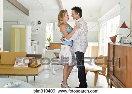 Couple hugging in living room View Large Photo Image Stock Photo - Couple hugging in living room. Fotosearch