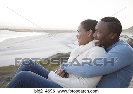 Couple hugging on cliffs over beach View Large Photo Image Stock Photography - Couple hugging on cliffs over beach. Fotosearch