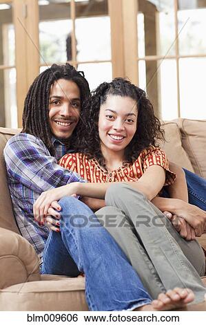 Couple hugging on sofa View Large Photo Image Stock Photograph - Couple hugging on sofa. Fotosearch
