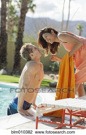 Couple kissing at poolside View Large Photo Image Stock Image - Couple kissing at poolside. Fotosearch