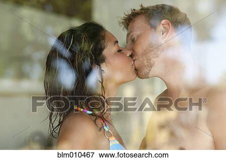 Stock Photo - Couple kissing behind window. Fotosearch